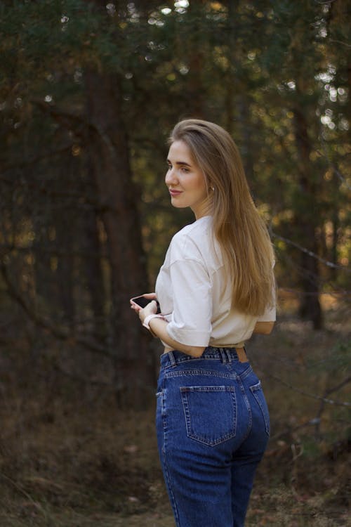 Young Woman in a Casual Outfit Standing in the Forest