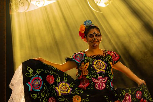 Free Colorful Dia de Muertos dancer in traditional Mexican attire, performing with artistic makeup. Stock Photo