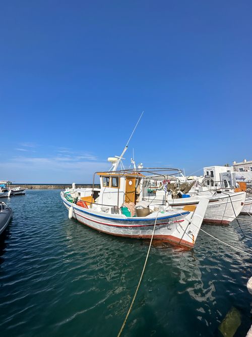 Free Colorful fishing boats docked in Paros harbor, Greece, under a clear blue sky. Stock Photo