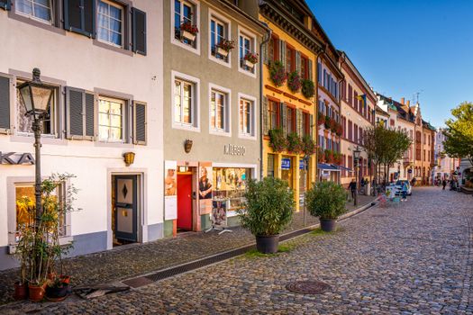 Picturesque cobblestone street in Freiburg im Breisgau, Germany, showcasing colorful historic buildings.