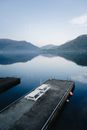 Peaceful lake view with mountains and pier at Sandeid, Norway. Perfect reflection and tranquility.