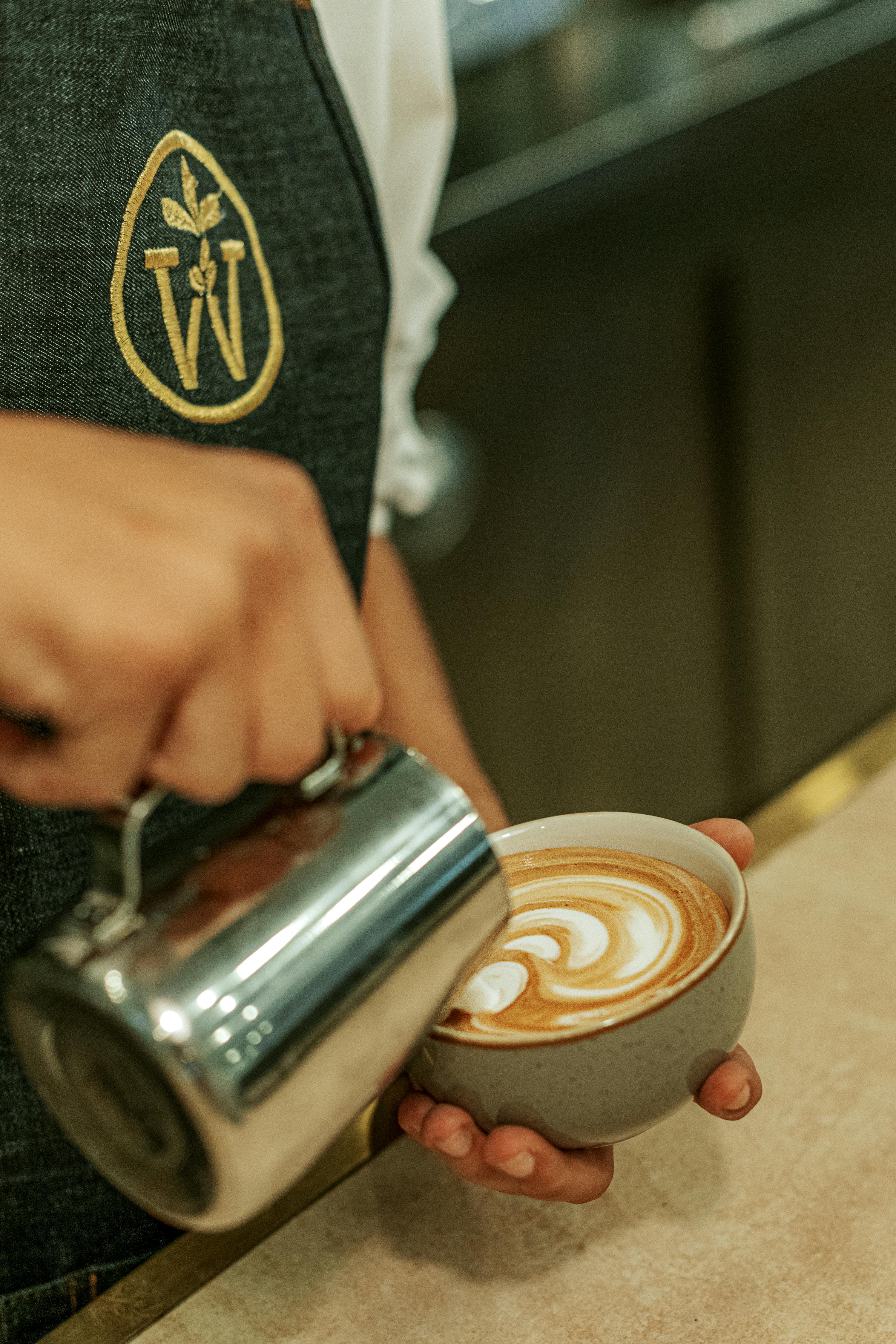 Close-up of a barista crafting latte art in a café in Baku, Azerbaijan.
