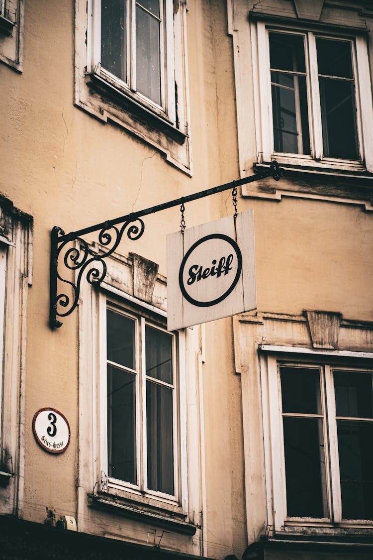 Old Advertising Sign Hanging On Wall Of Townhouse