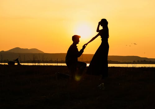 Silhouette of a couple's proposal at sunset with a scenic backdrop in Nashik, India.