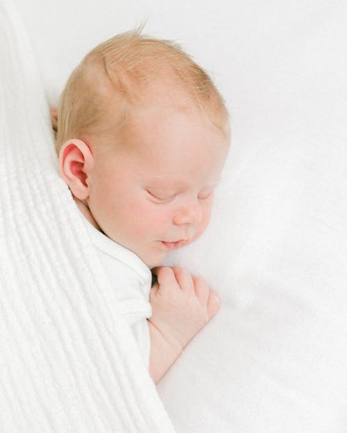 Little Baby Sleeping on Tummy Under a White Blanket