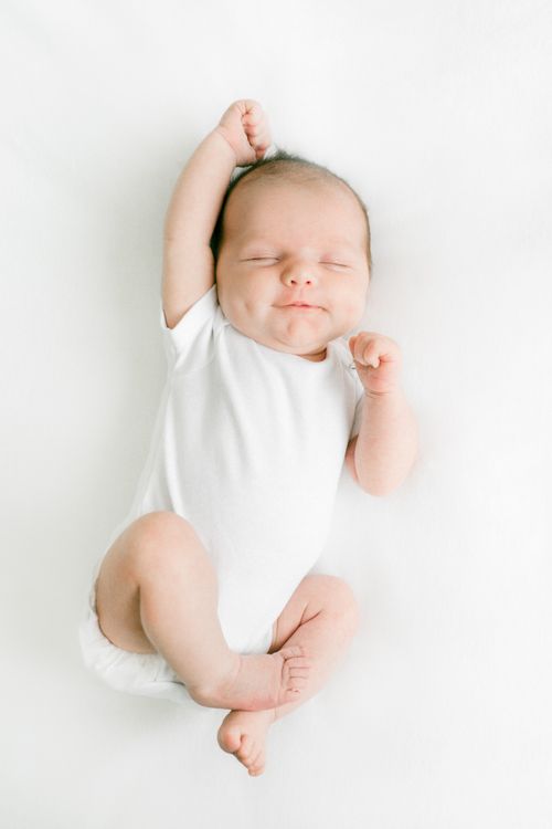 Free Adorable baby peacefully sleeping on a white background in a relaxed pose. Stock Photo