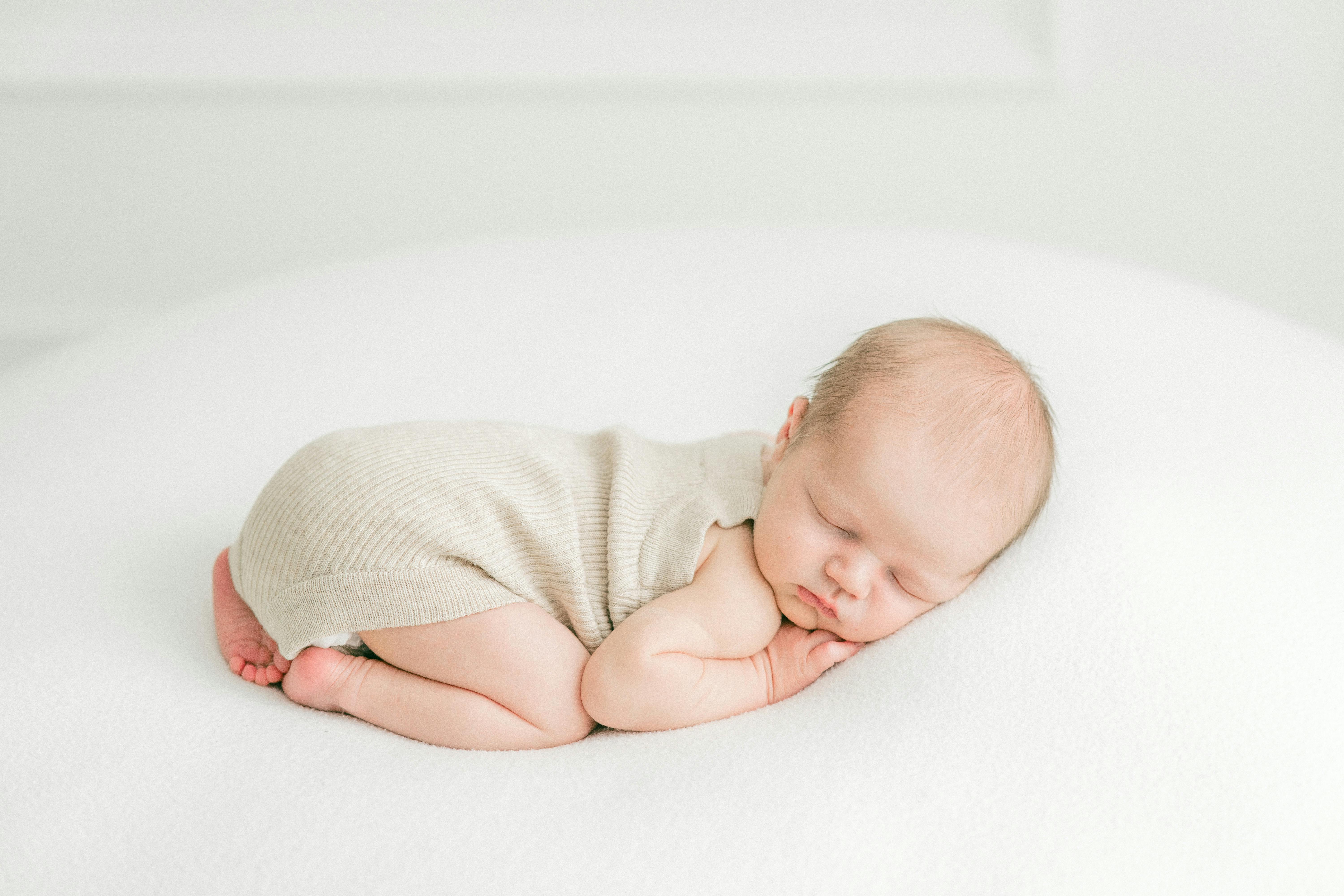 A Sleeping Baby Lying on an Open Book · Free Stock Photo