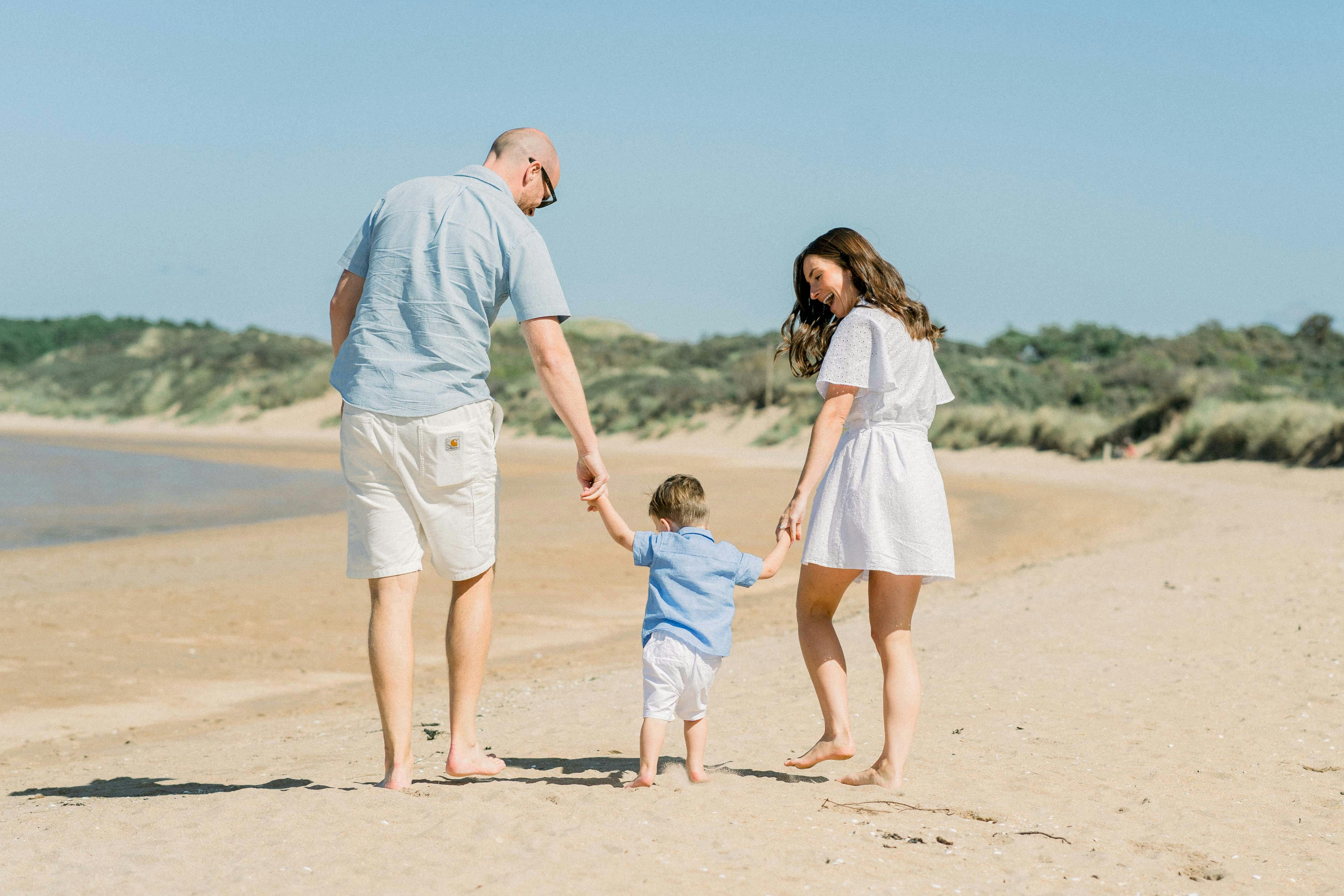 Parents Leading Their Little Son by the Hands Along the Beach · Free Stock  Photo