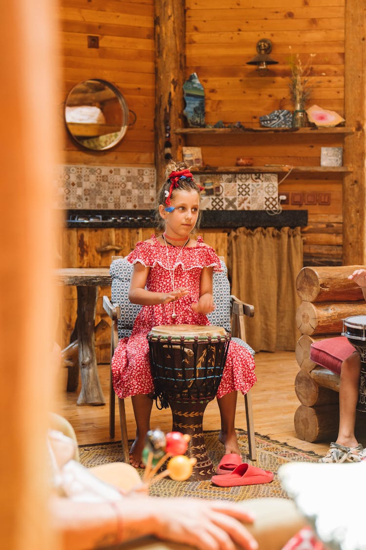 Girl In Dress Playing On Drum