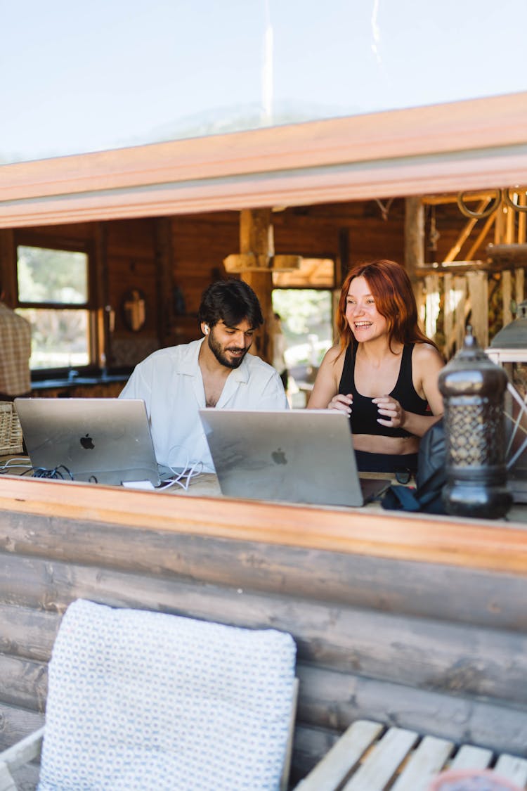 Woman And Man Working On MacBooks