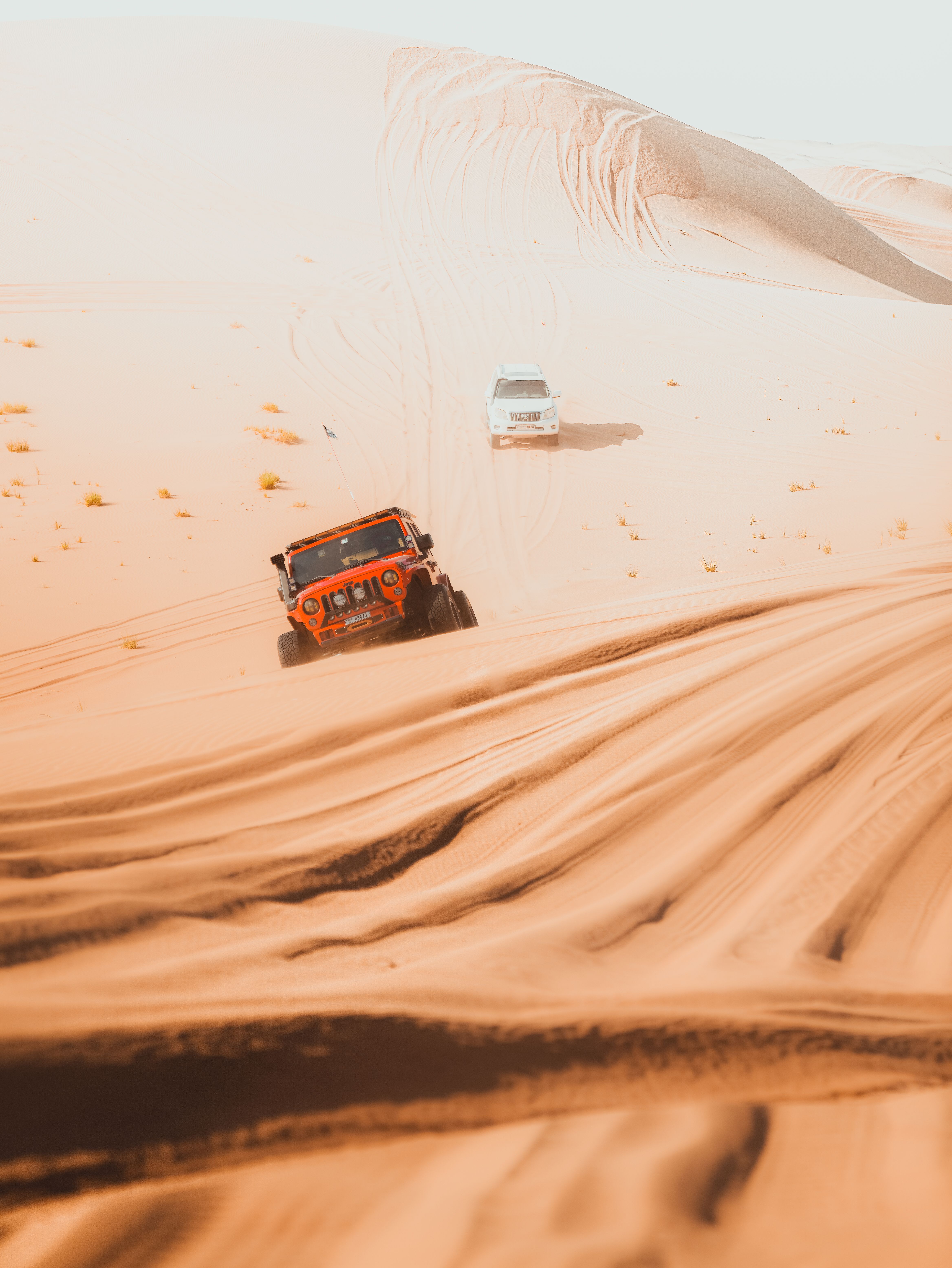 Off-road vehicle throwing up sand on a dune route