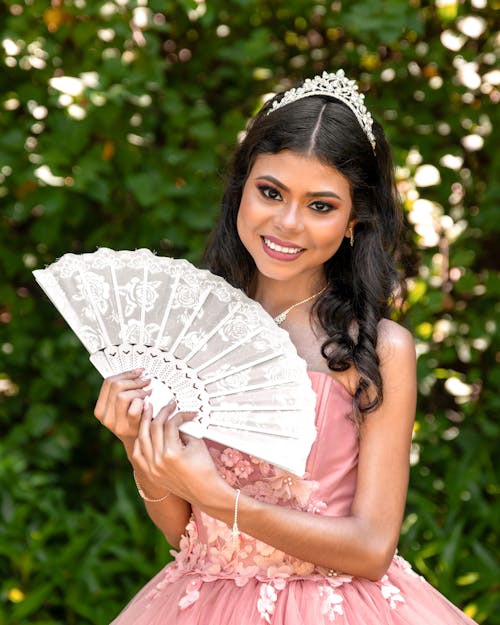 Gorgeous Woman with Tiara on Head Posing with White Hand Fan