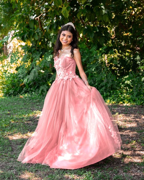 Young Woman Wearing a Pink Princess Dress Posing Outside 