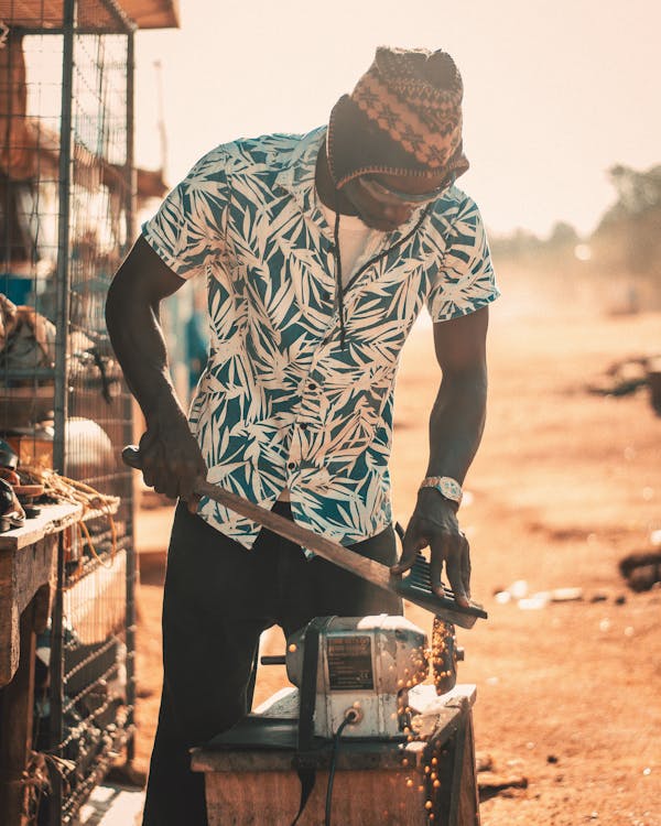 Man Using a Grinder to Make a Tool