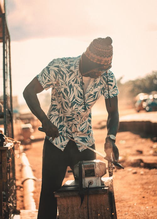 Man Using a Grinder to Make a Tool