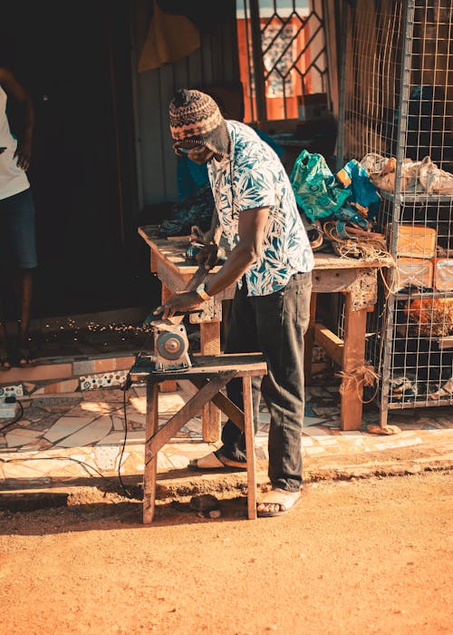 Man Using a Grinder to Make a Tool