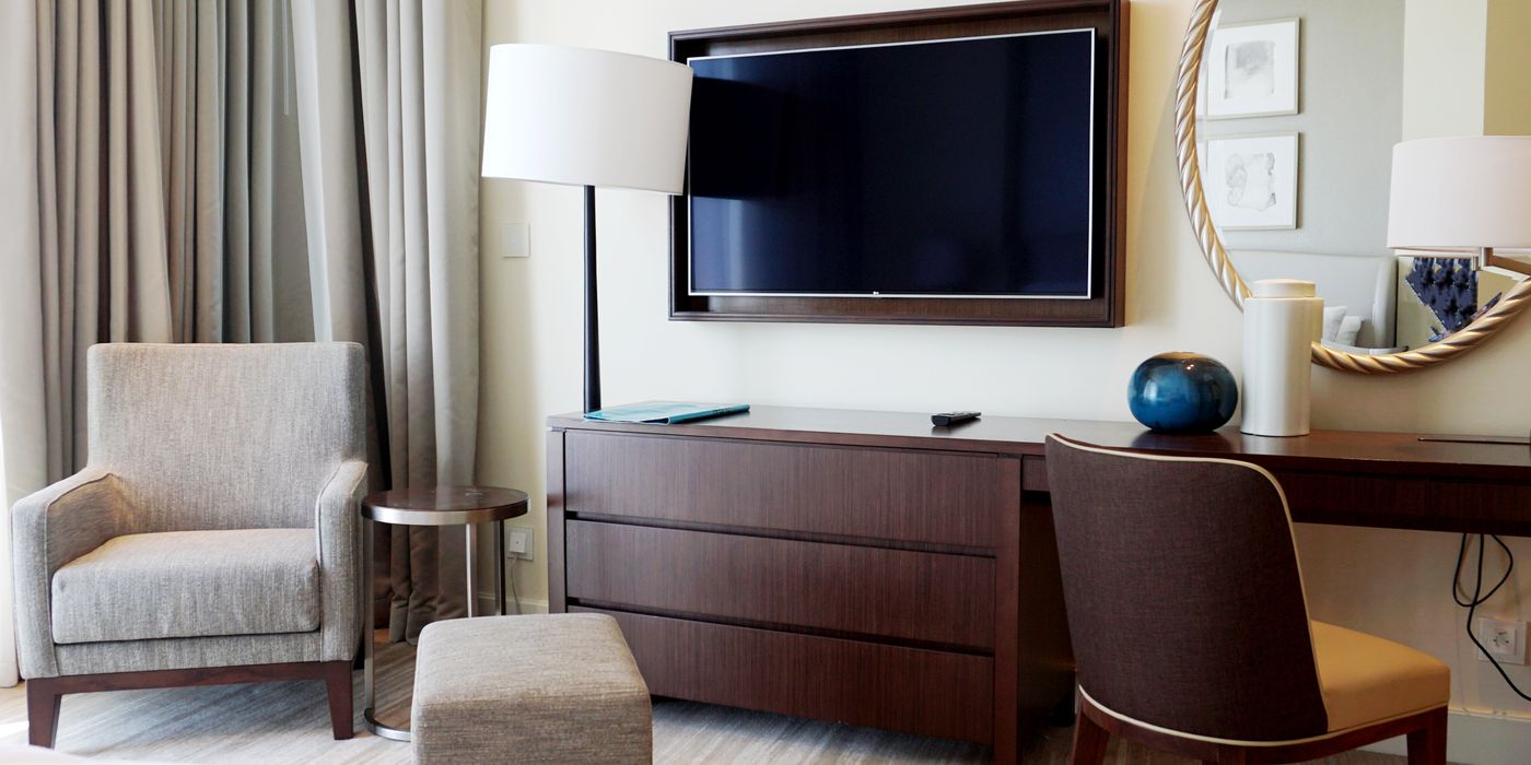 Modern hotel room interior with bed and wall-mounted television