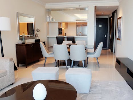 Elegant dining room with modern furniture, connected to a stylish kitchen.