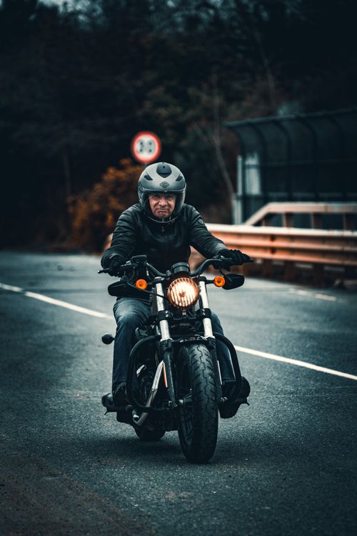 Free Man riding a motorcycle on a rural road in Anadolufeneri, İstanbul, Türkiye. Stock Photo