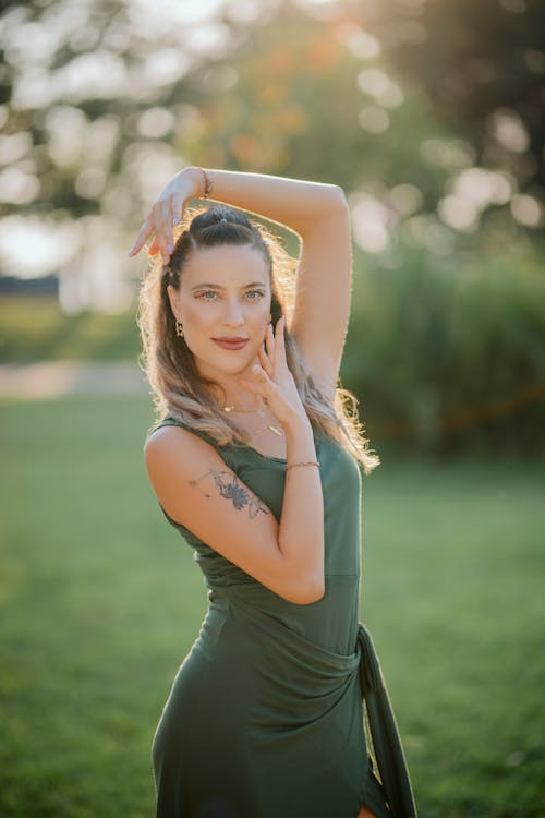 Smiling Model Posing in Green Dress in Park