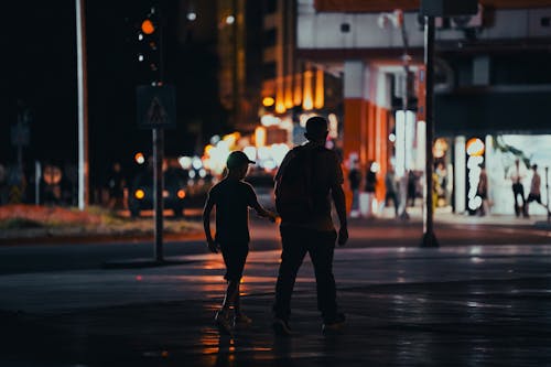 Father Walking with Son in Town at Night