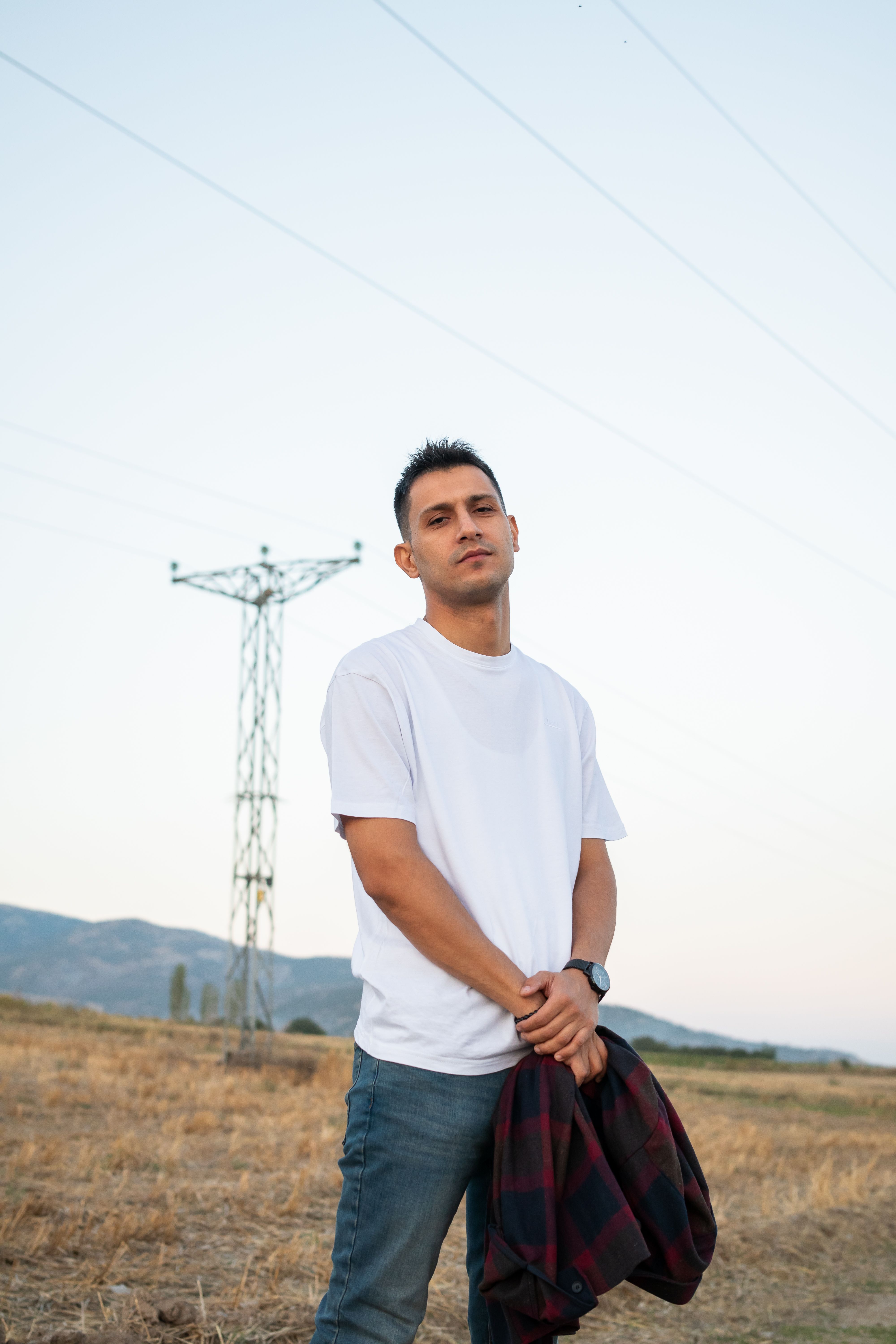 Man standing in an open field at dusk, photo by Orhan Pergel on Pexels