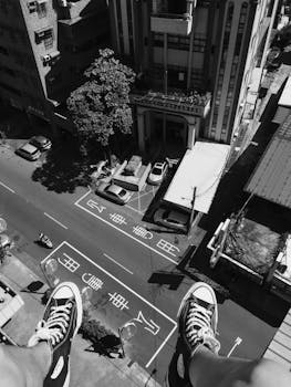 一张高角度黑白照片展示了运动鞋在繁华的城市街道上