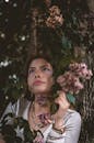 在自然界中，女人与项链被花和树包围，看起来令人愉快
