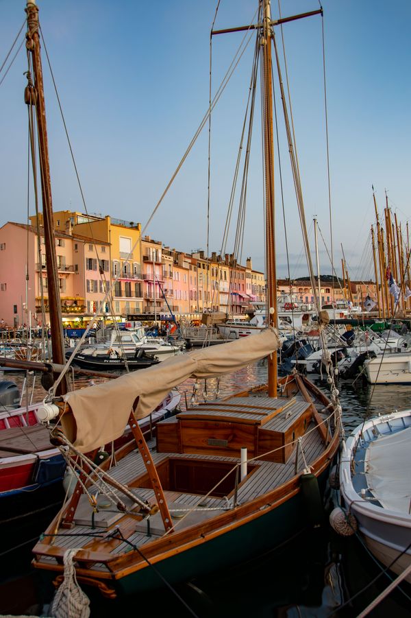 Wooden sailing boats moored in a harbour at sunset