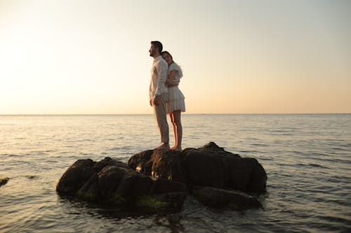Couple Hugging on a Rock in a Sea