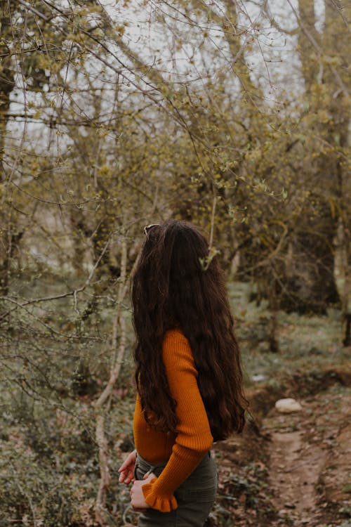 Woman Standing in a Forest in Autumn 