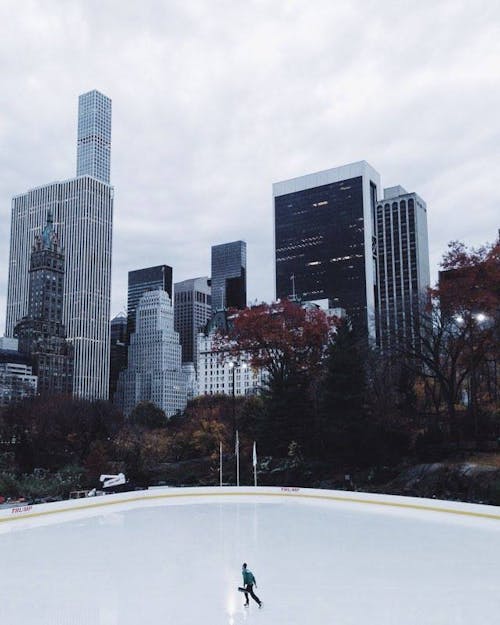 Lone Person Ice Skating Under Heavy Clouds