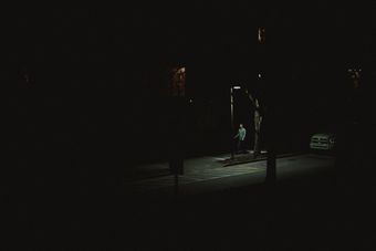 A lone figure under a streetlight on a dark city block — Jamaal Hutchinson on Pexels