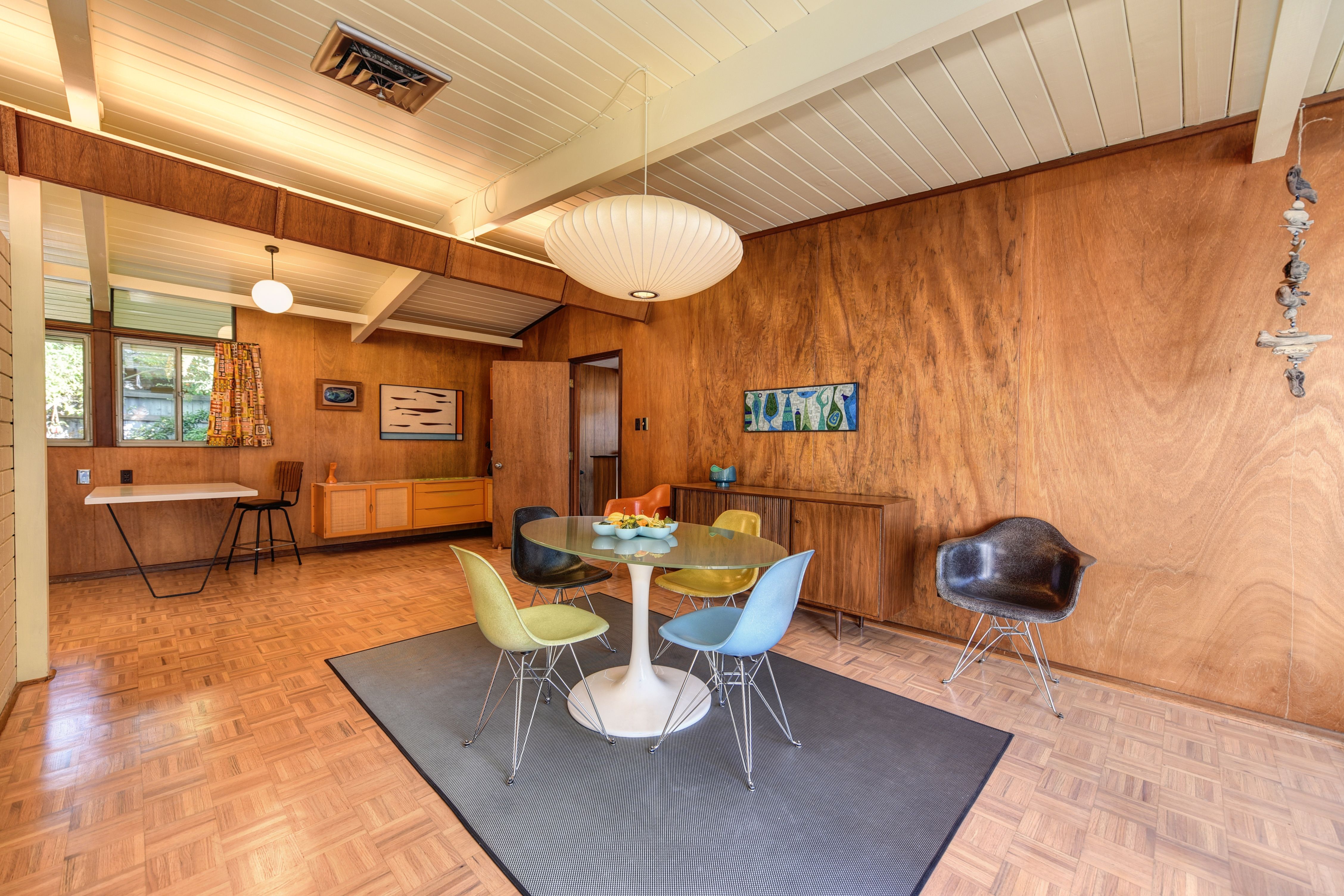 Stylish mid-century modern dining room featuring colorful chairs and a wooden interior design.. pexels, stylish, century