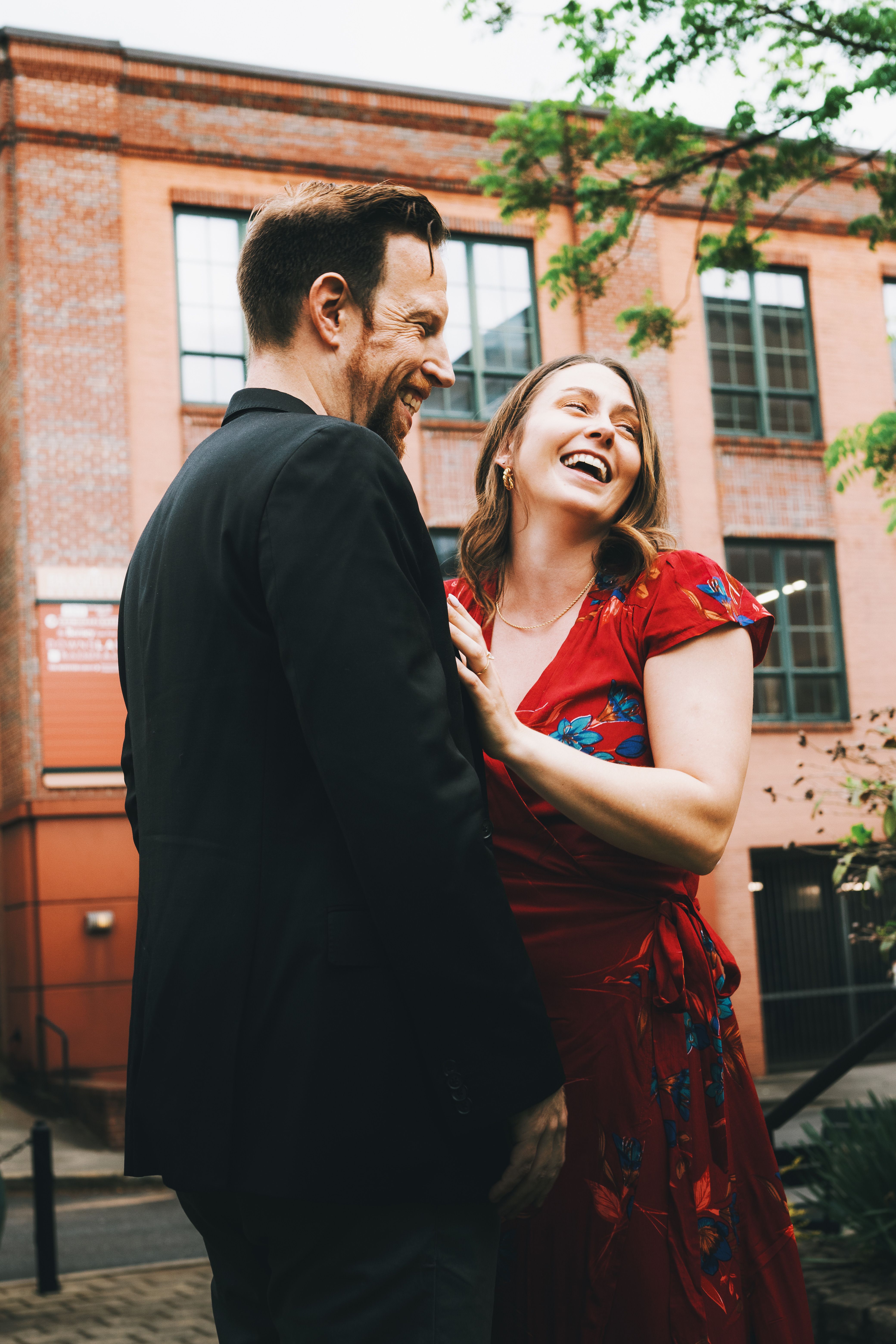A couple laughing and hugging together outdoors