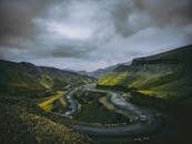 一条蜿蜒的道路，穿行于山势险峻的景观之中，头顶乌云密布