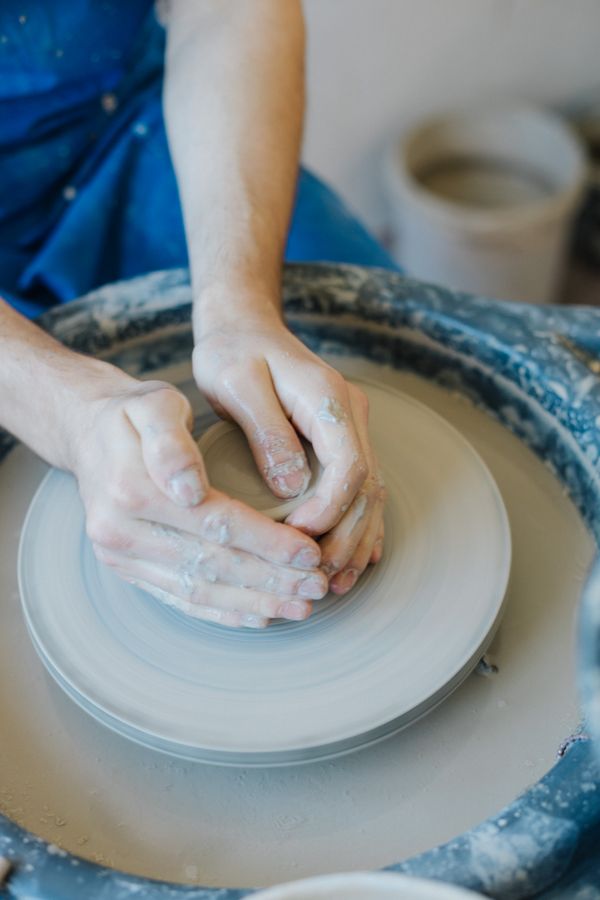 Hands centring clay on a potter's wheel, photo by Dominika Polakova on Pexels