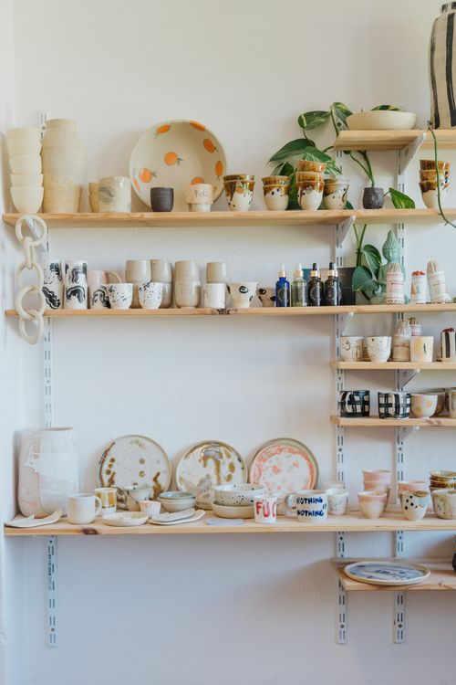 Ceramic bowls and cups on shelves by Dominika Polakova on Pexels