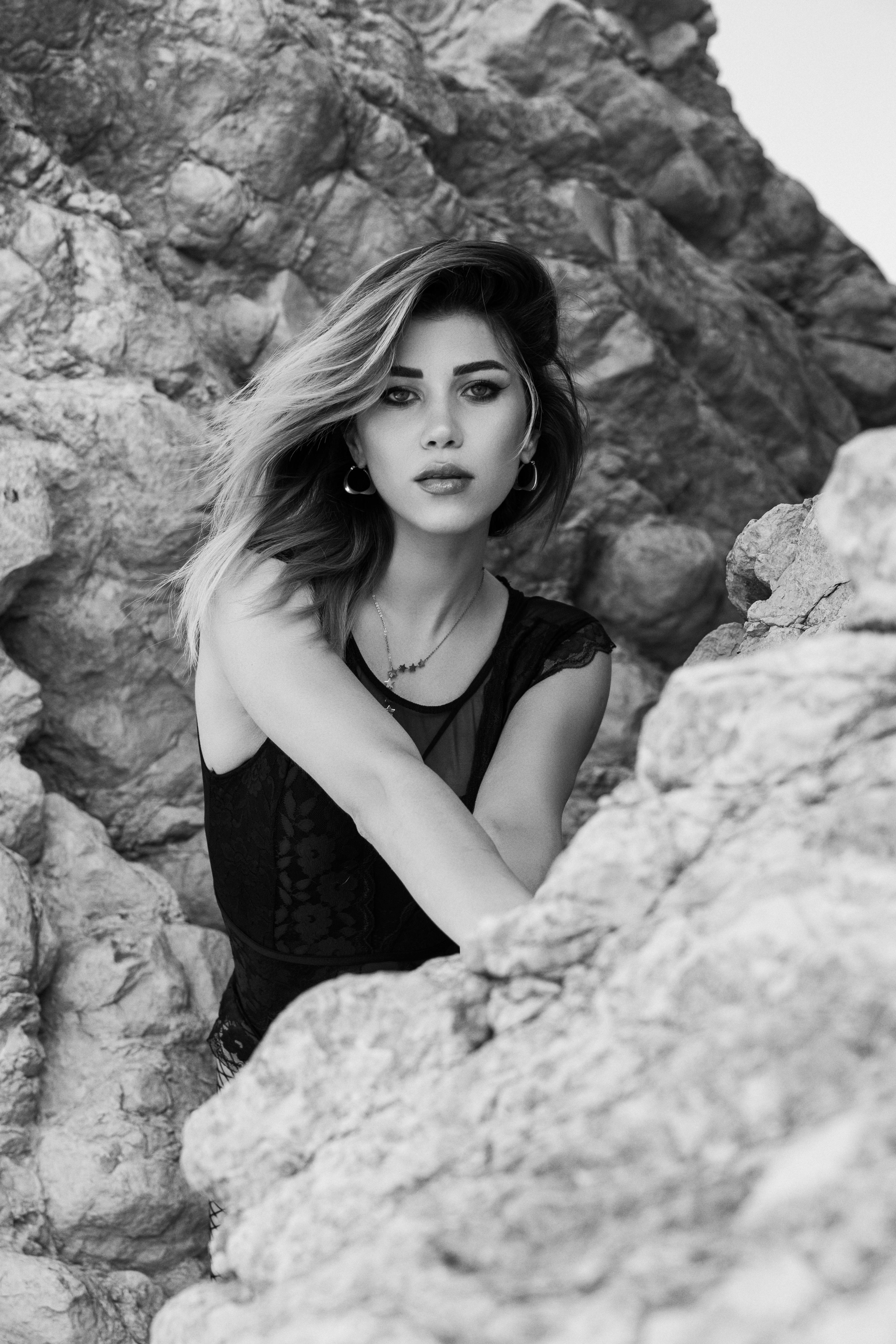 a woman in black and white posing on a rock