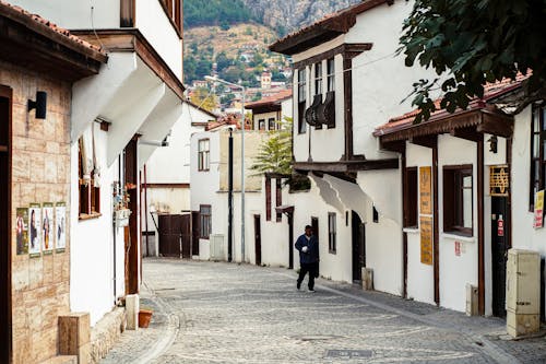 Man Walking on Cobblestone Street in Old Town