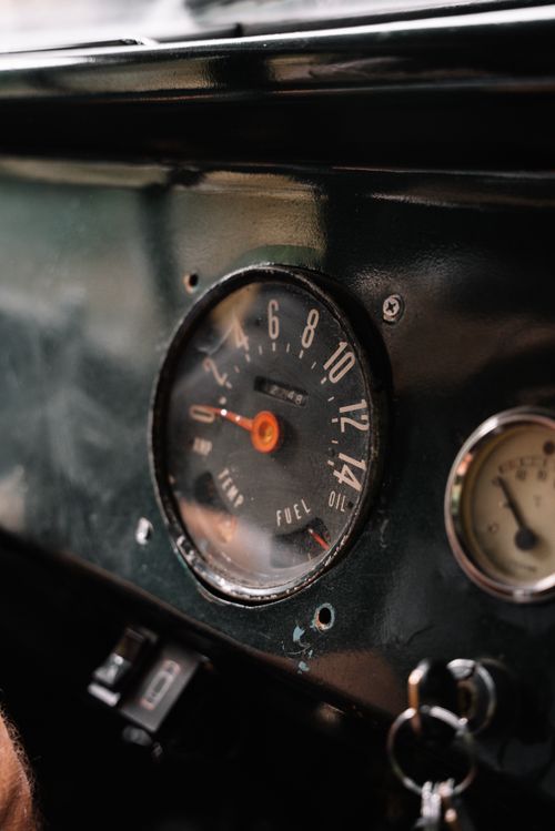 Free Close-up of a vintage car dashboard featuring a speedometer and gauges with keys in ignition. Stock Photo