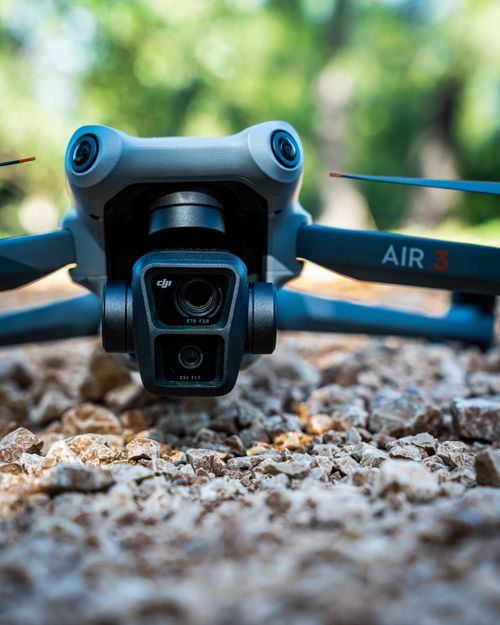 Free Detailed view of a drone on rough gravel, set in a lush outdoor scene. Stock Photo