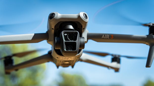 Detailed close-up shot of a drone in flight against a vibrant blue sky.