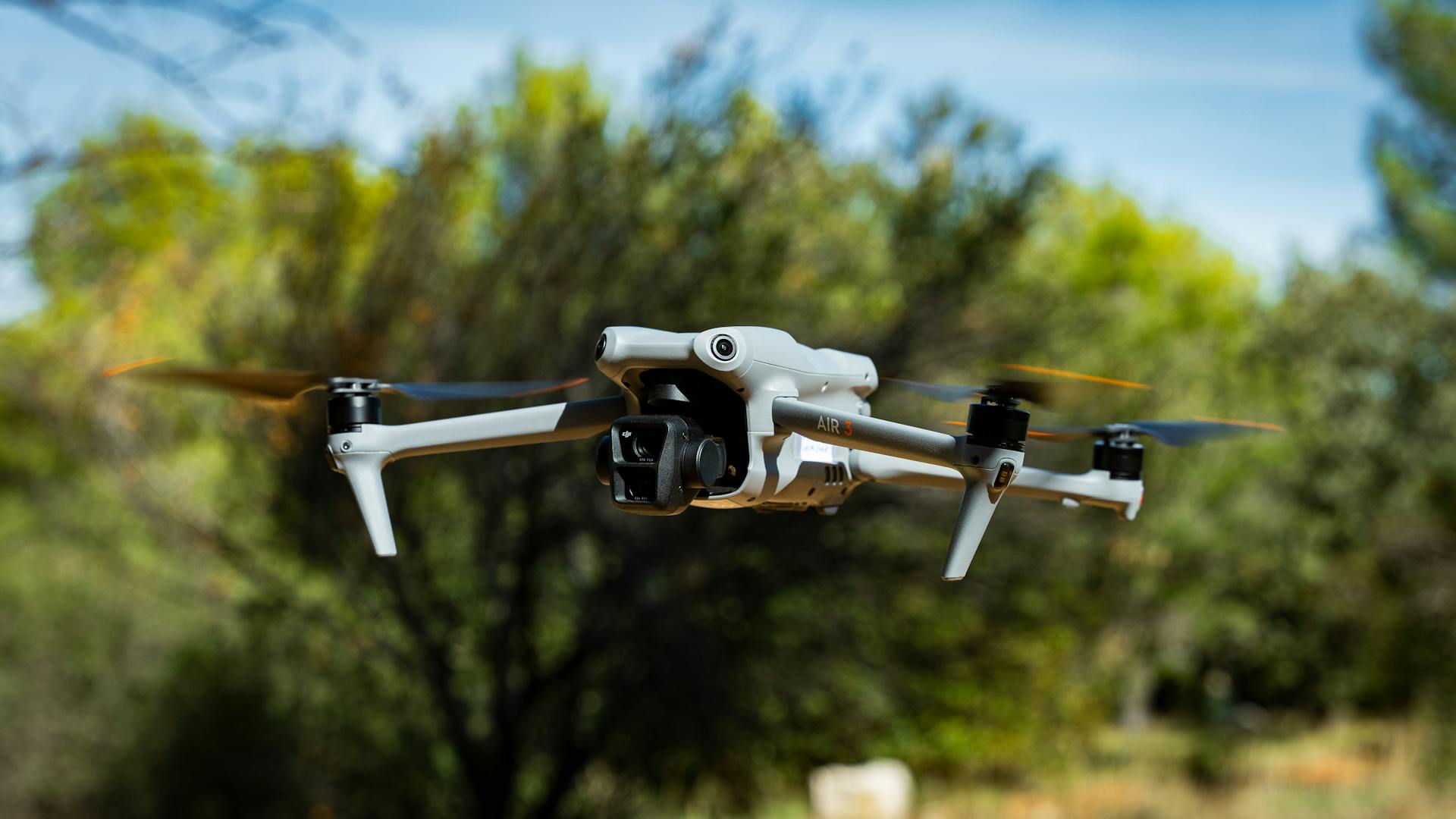 A DJI drone in flight captured in a forest setting near Marseille, France.