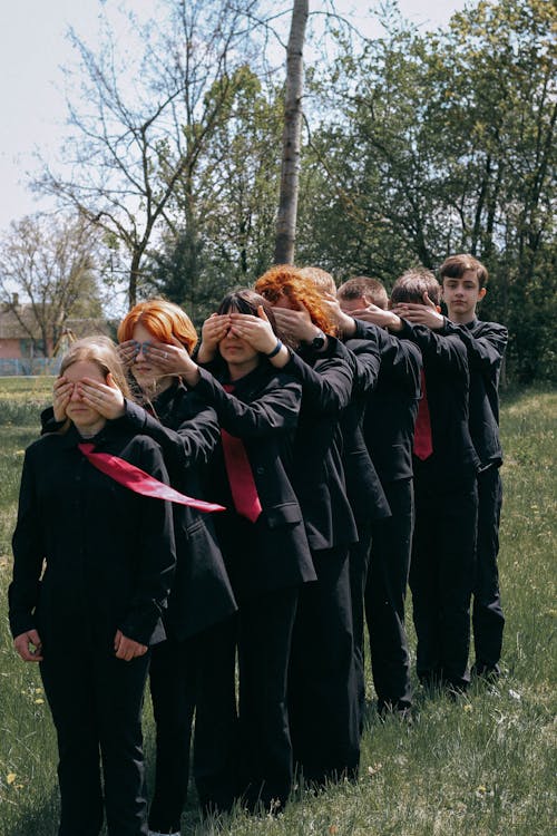 Teenagers Wearing Suits Covering Their Faces