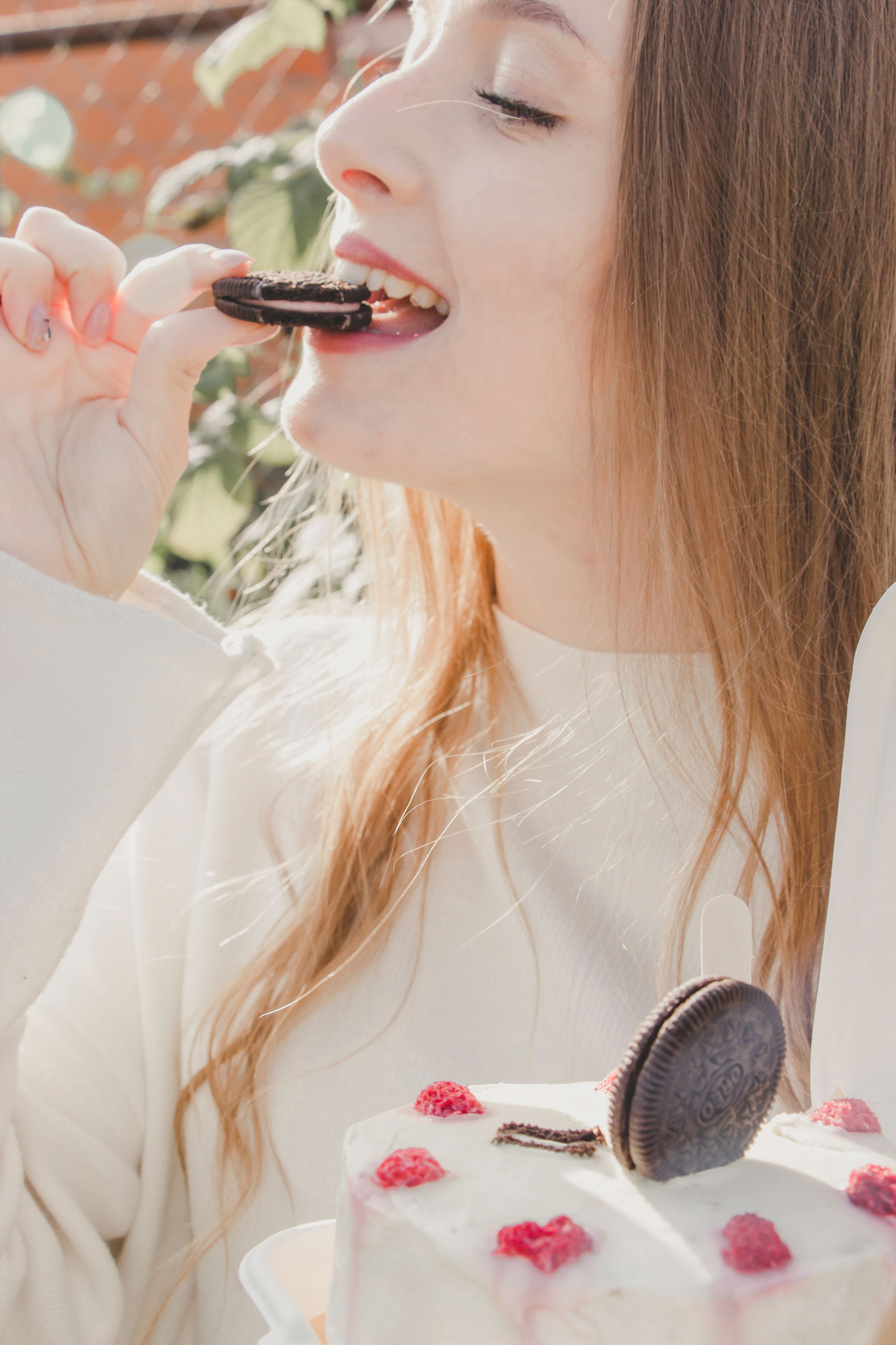 woman eating cookie from cake