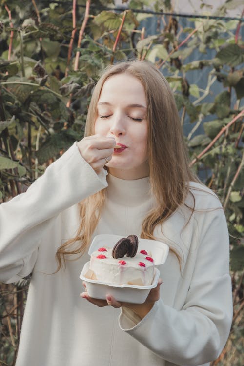 Woman Eating Cake with Eyes Closed