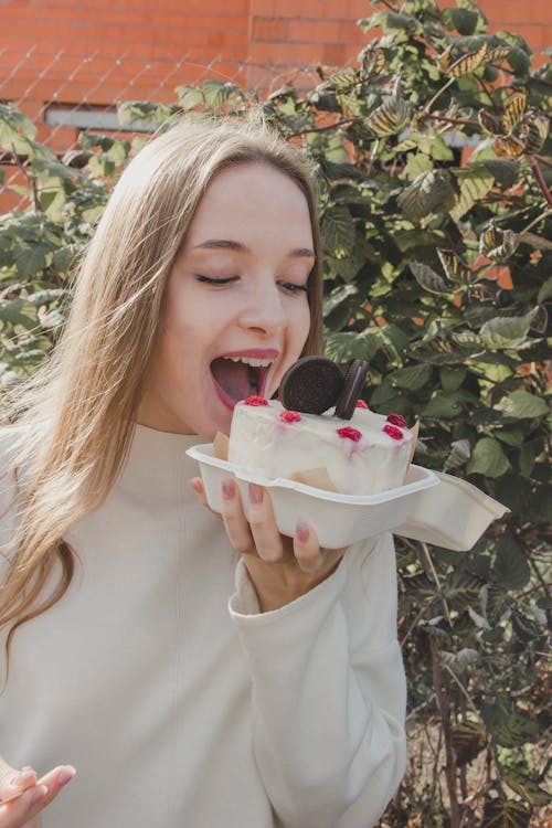 Woman Holding Cake and Eating
