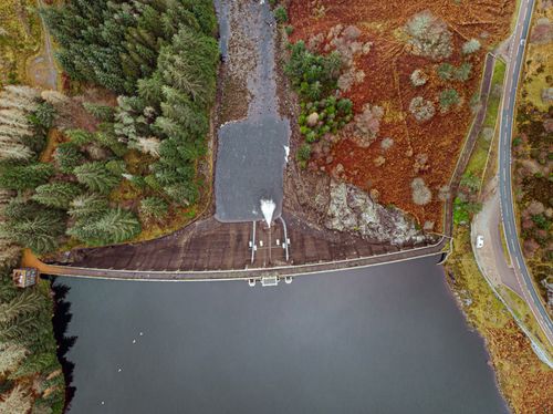 Free Stunning aerial image of a dam surrounded by trees in the Scottish Highlands. Stock Photo