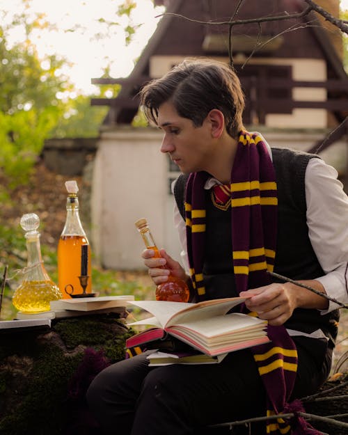 Man in Harry Potter Costume with Books and Magic Potions